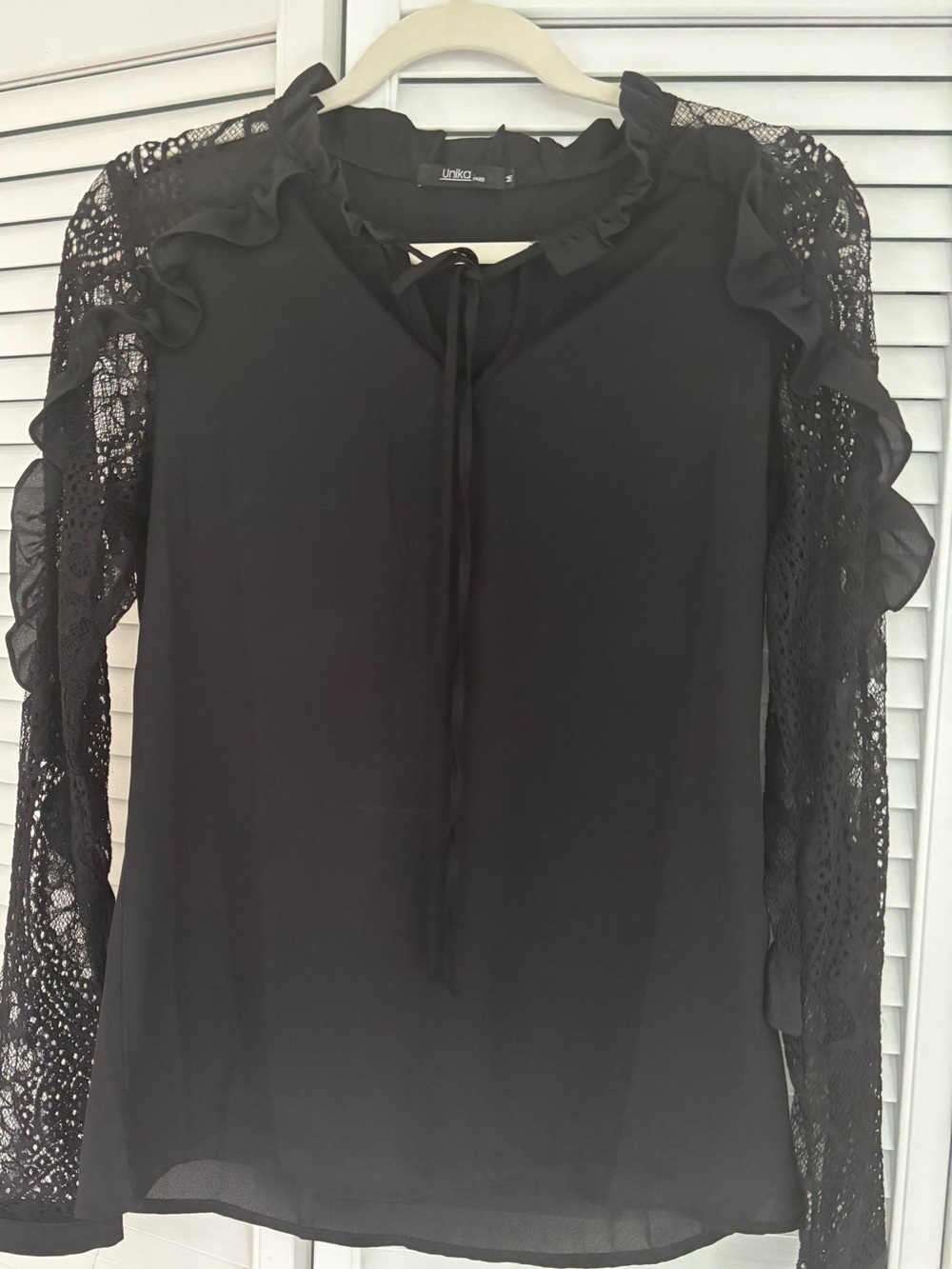 Unika black blouse detailed lace sleeves, a ruffled high neckline.M